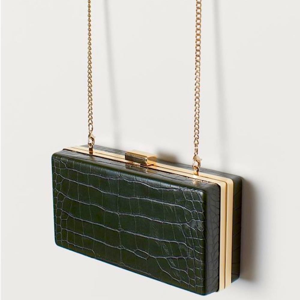 Rectangular clutch bag in grained faux leather with a metal frame.